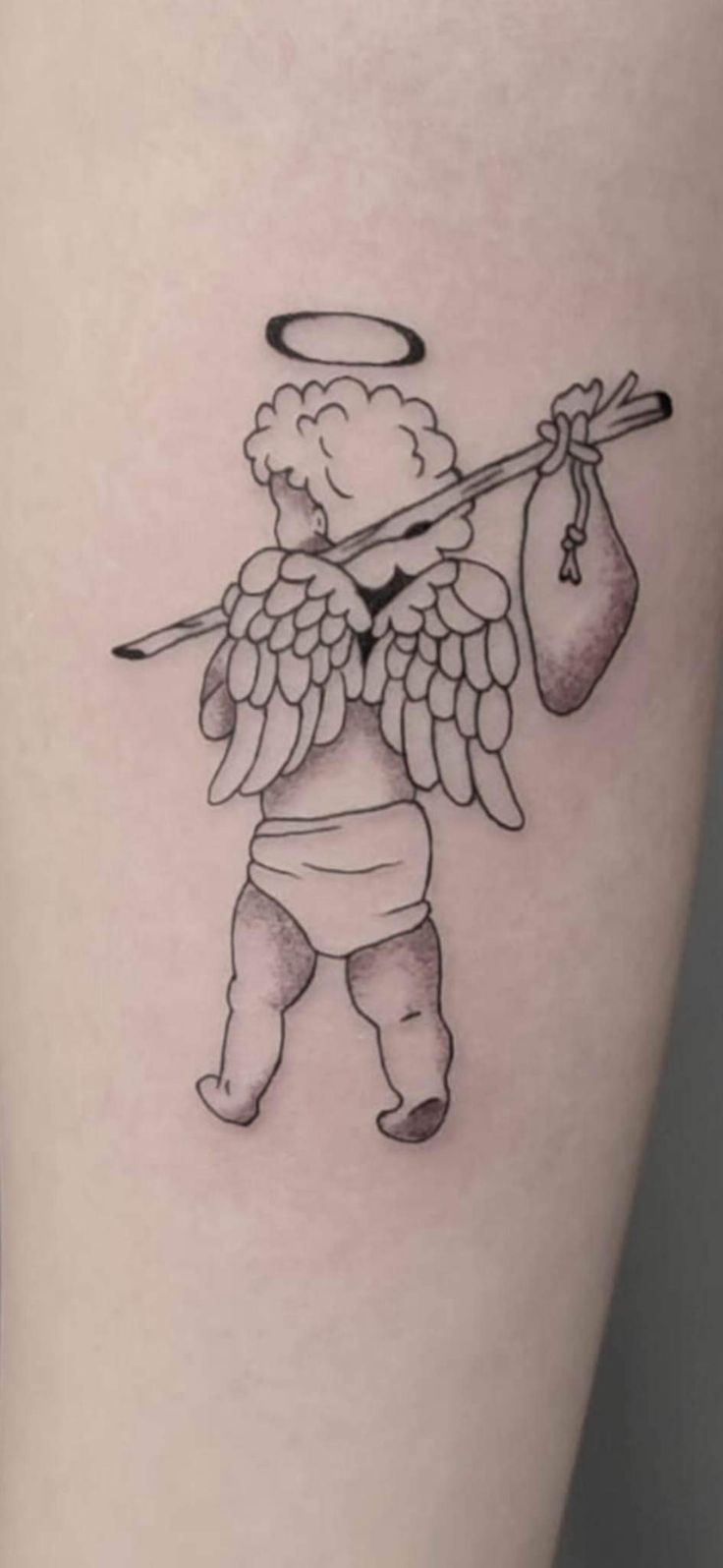 an angel tattoo on the thigh with a bag of money in it and an angel holding a staff