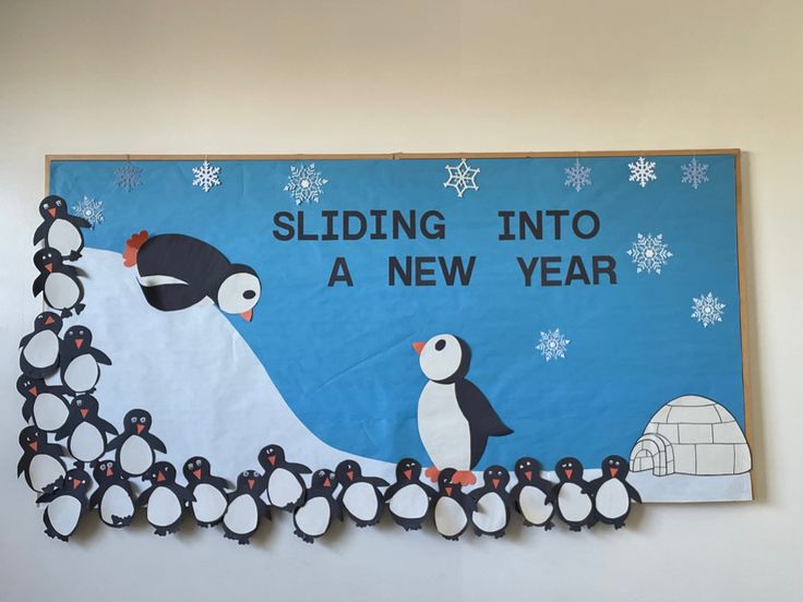 a bulletin board with penguins and an igloose in the background that says sliding into a new year