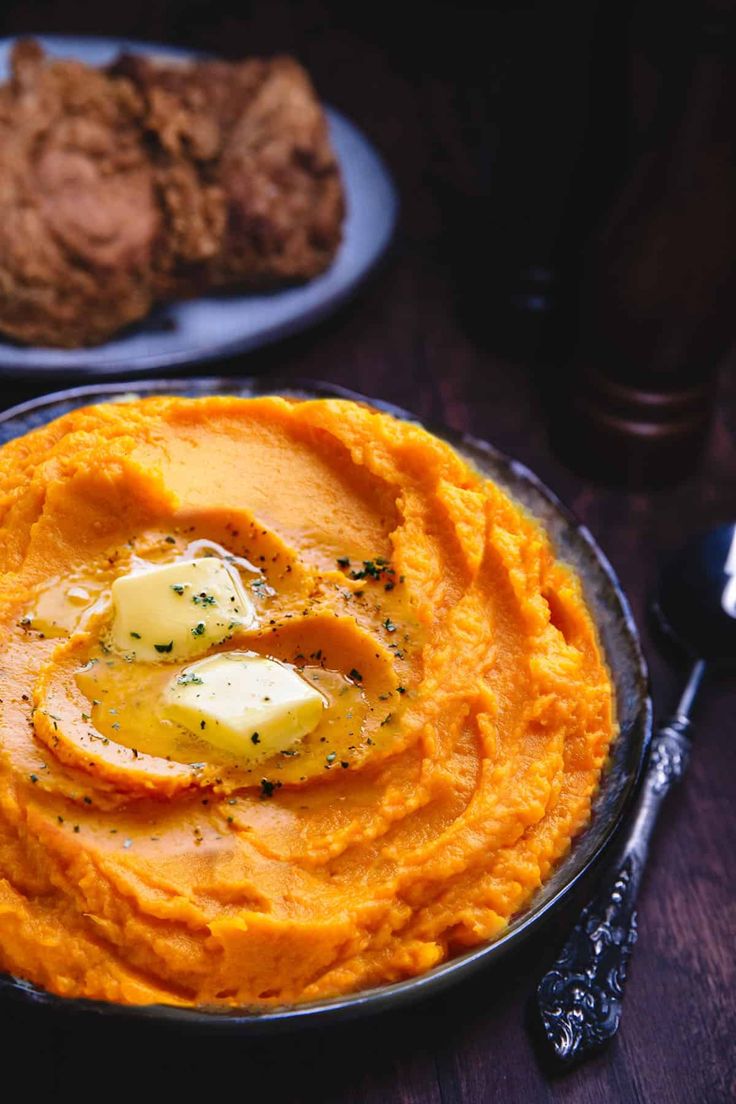 a bowl of mashed potatoes with an egg in the center on a wooden table