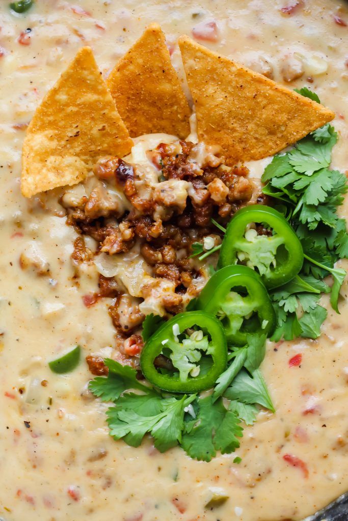 mexican dip with tortilla chips and cilantro garnished with green peppers