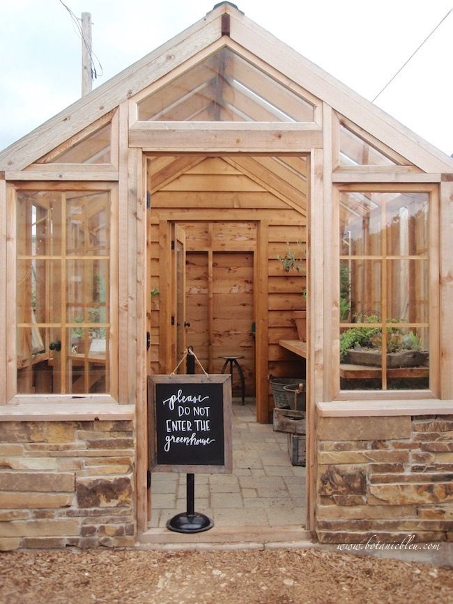 a small wooden building with windows and a sign