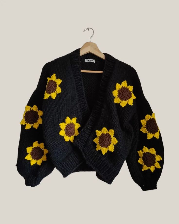 a black sweater with sunflowers on it