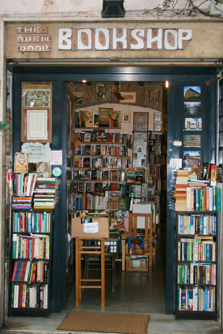 a book shop with lots of books on the shelves and tables in front of it