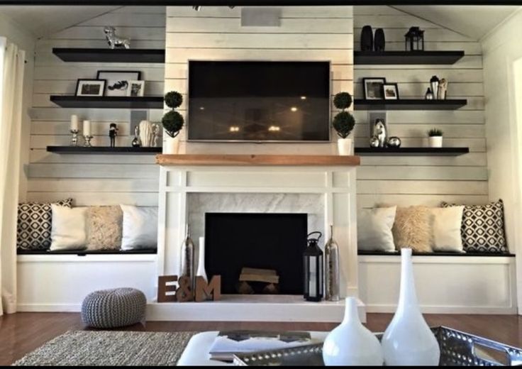 a living room filled with furniture and a flat screen tv mounted on the wall above a fire place