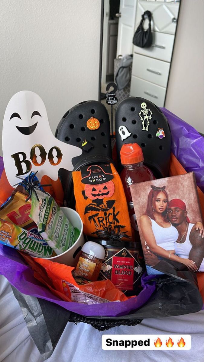 a basket filled with halloween items on top of a bed