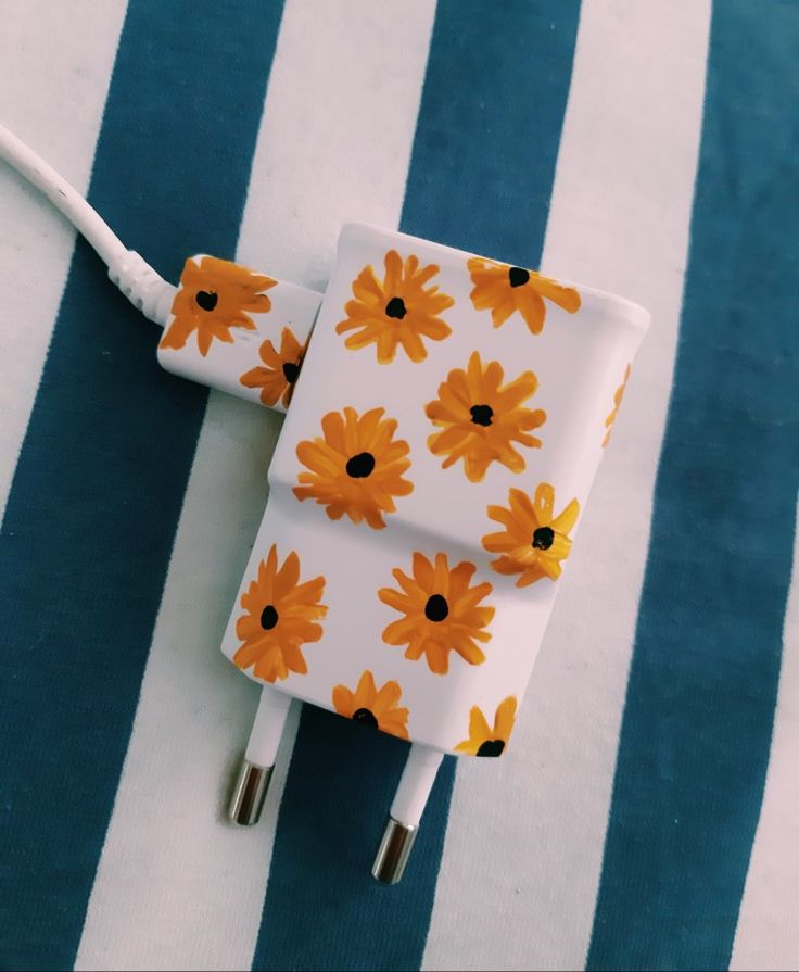 an orange and white flowered charger sitting on top of a blue and white striped blanket