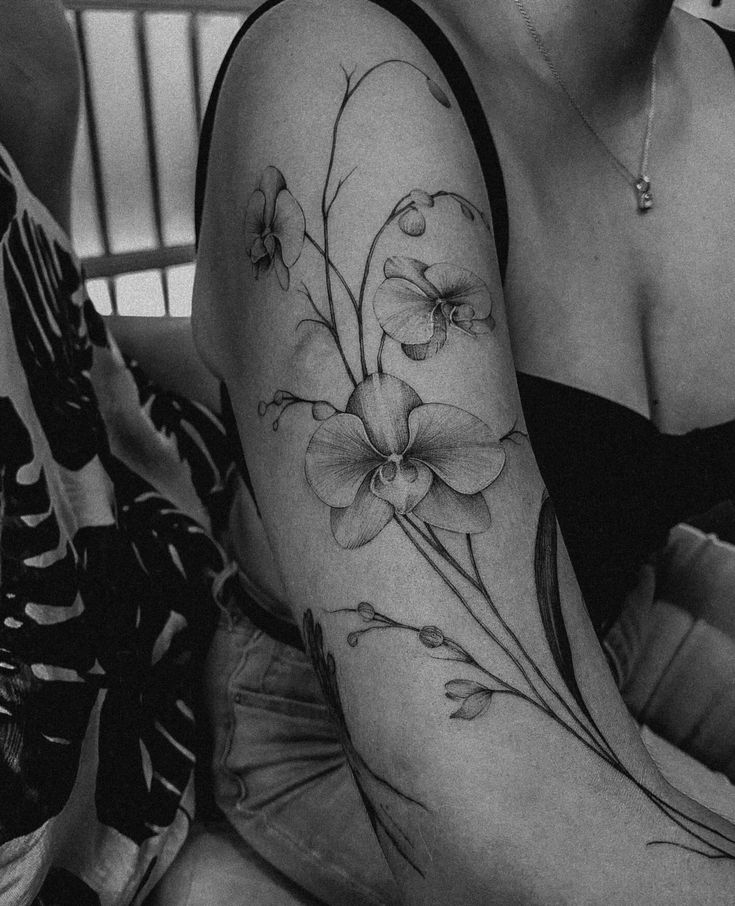 black and white photo of a woman with flowers on her arm