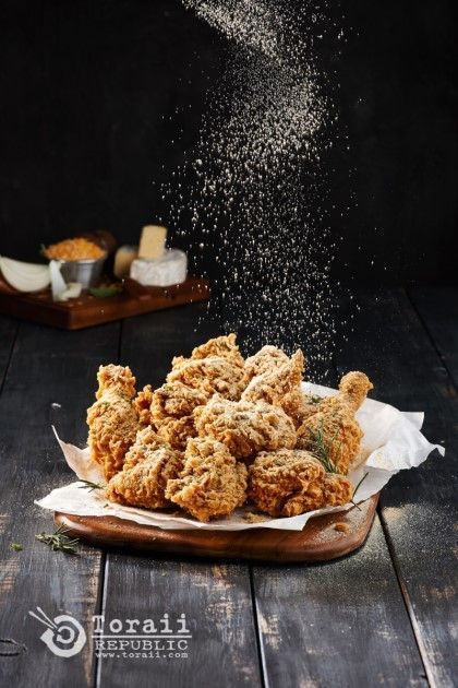 some food that is sitting on a wooden table and sprinkled with salt in the air