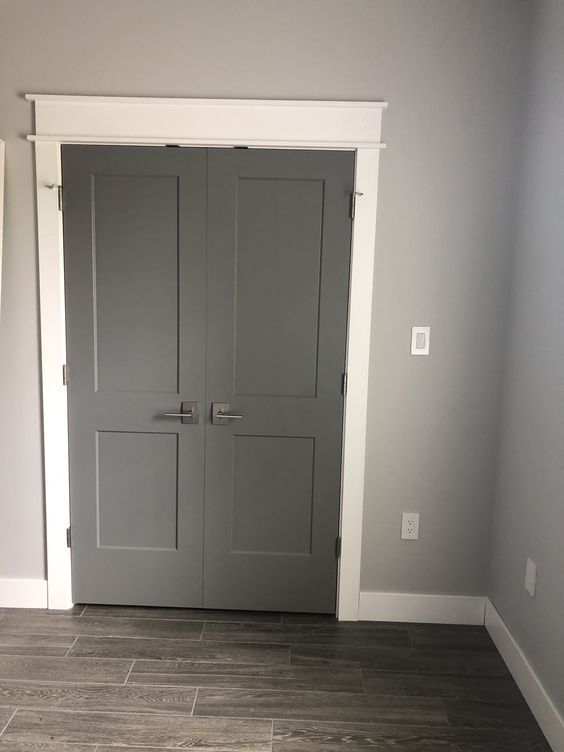 an empty room with two gray doors in it