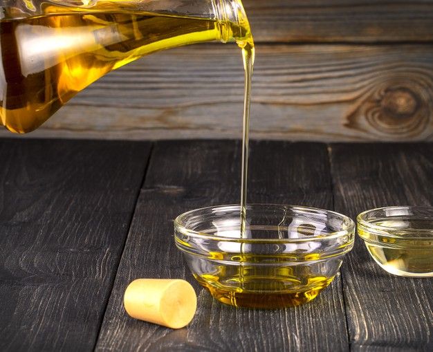 a glass bowl filled with oil next to two small bowls