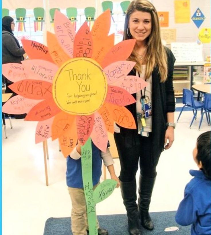 a woman standing next to a child in front of a flower with words written on it