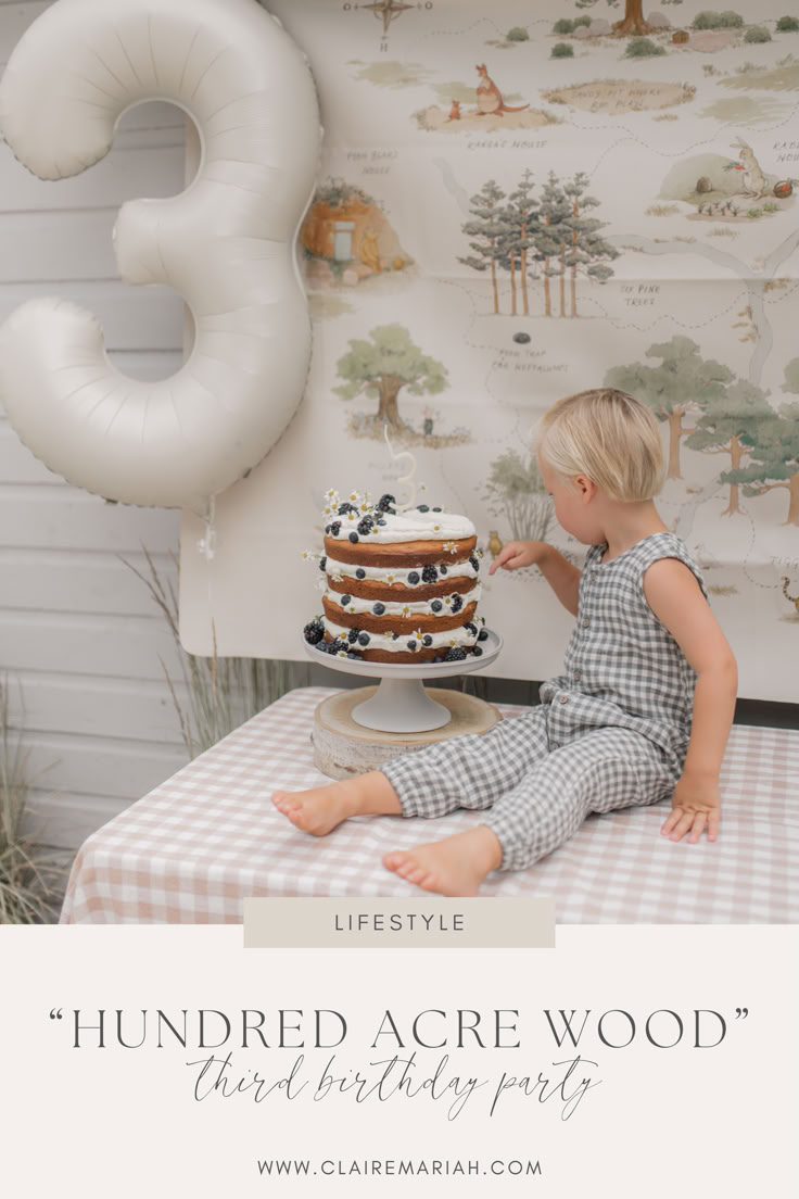 a little boy sitting on top of a table next to a cake