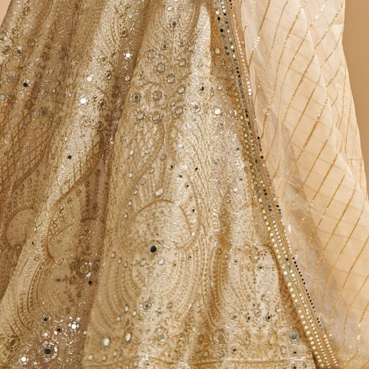 Featuring a stunning ivory organza blouse adorned with zari and mirror work that glisten with every step. Teamed with an absolutely ethereal ivory organza lehenga and a coordinating ivory beautiful dupatta embellished with sequins and mirror detail. Composition : Organza Care: Dry Clean Only and Vacuum Storage This product can be customized for sleeves, length of blouse and neckline Delivery : 6-8 weeks as the product is hand crafted. Check Size Guide or choose MySize for free customisation (All Glamorous Tissue Silk Lehenga With Zari Work, Glamorous Organza Sharara With Mirror Work, Glamorous Organza Sets With Zari Work, Glamorous Tissue Silk Sets With Dupatta, Glamorous Chinon Lehenga For Festive Season, Glamorous Gold Lehenga With Resham Embroidery, Glamorous Georgette Anarkali Set For Wedding, Glamorous Organza Sharara For Festive Occasions, Diwali Glamorous Tissue Silk Lehenga