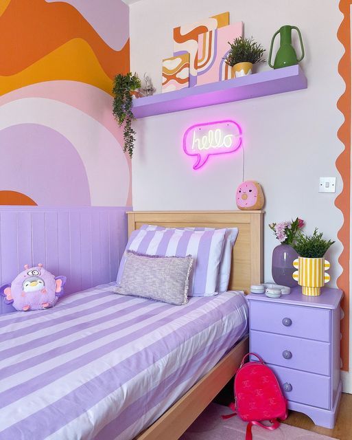 a bedroom decorated in pastel colors with pink, purple and orange accents on the walls