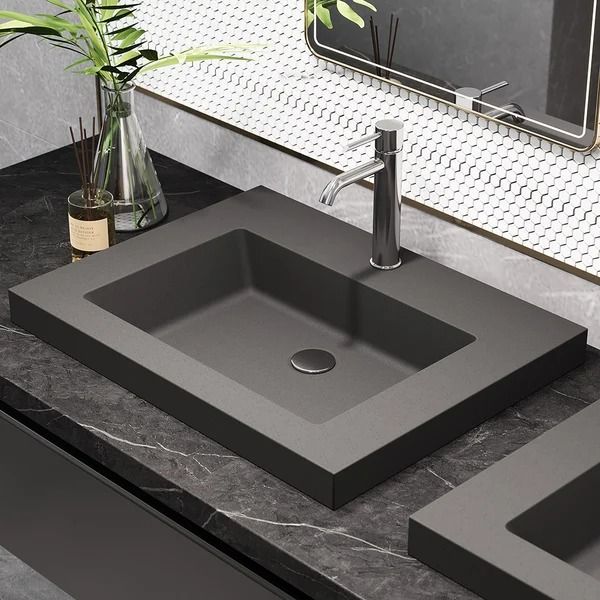 a bathroom sink sitting under a mirror next to a plant