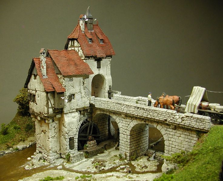 a miniature model of a castle with horses on the roof and water running under it