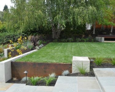 an outdoor garden with grass and trees in the background