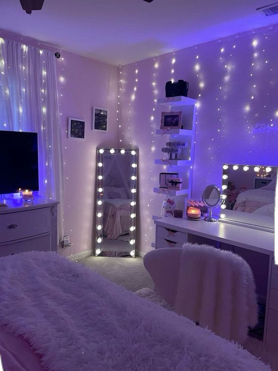 a bedroom decorated in white and purple with lights