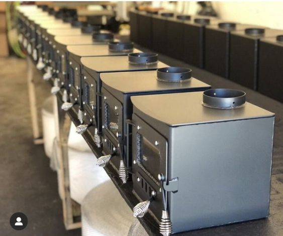 a row of ovens sitting on top of each other in front of rows of tables