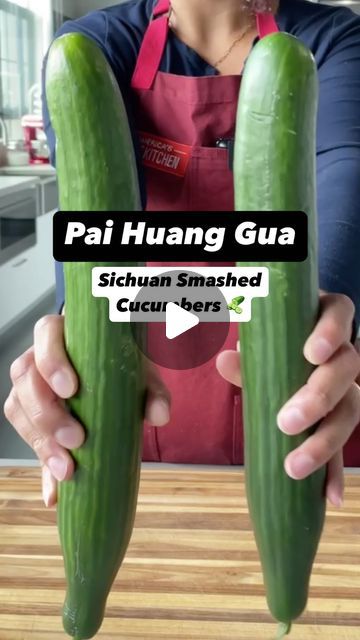 a woman holding two cucumbers in her hands with the words pai huang gua above them