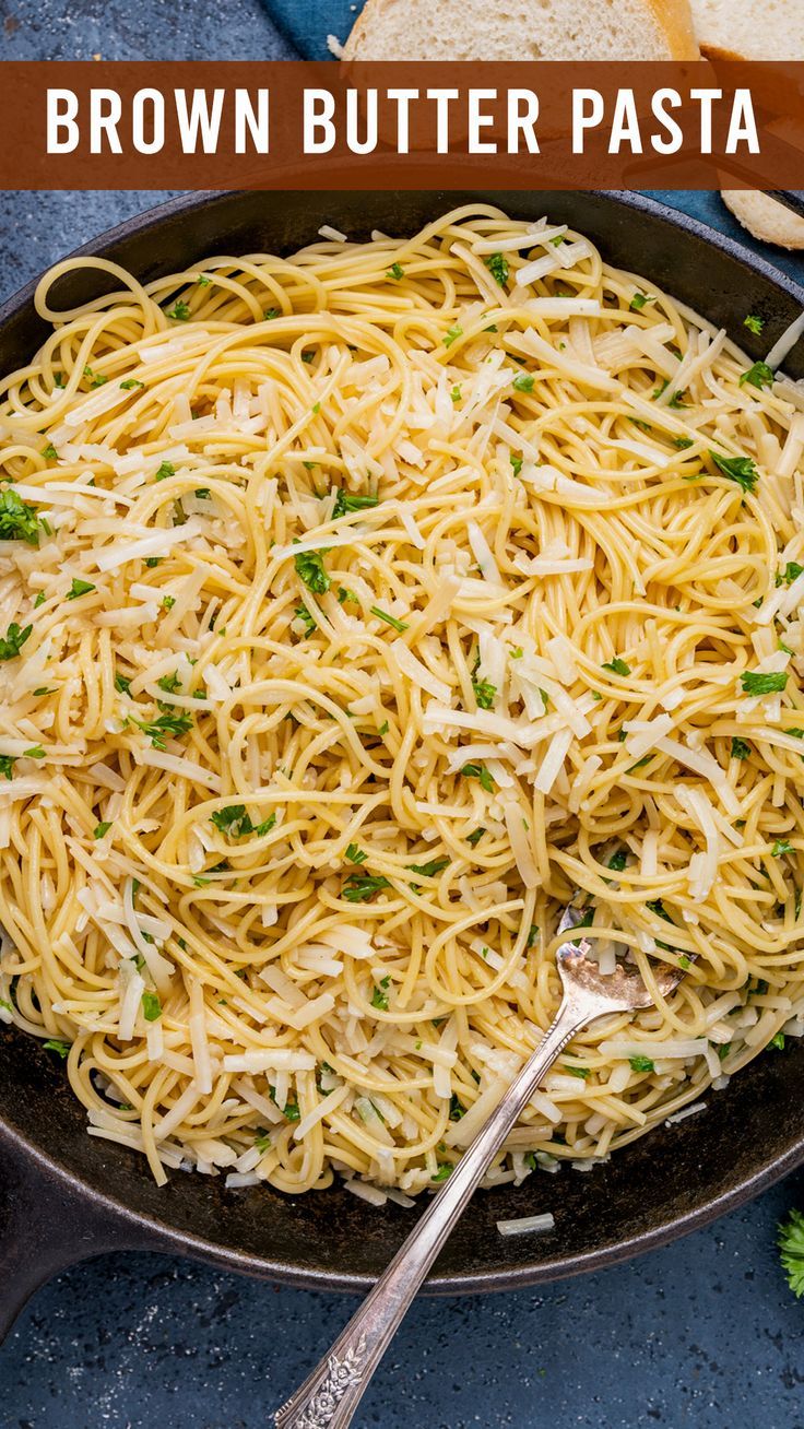 a skillet filled with pasta and topped with parmesan cheese