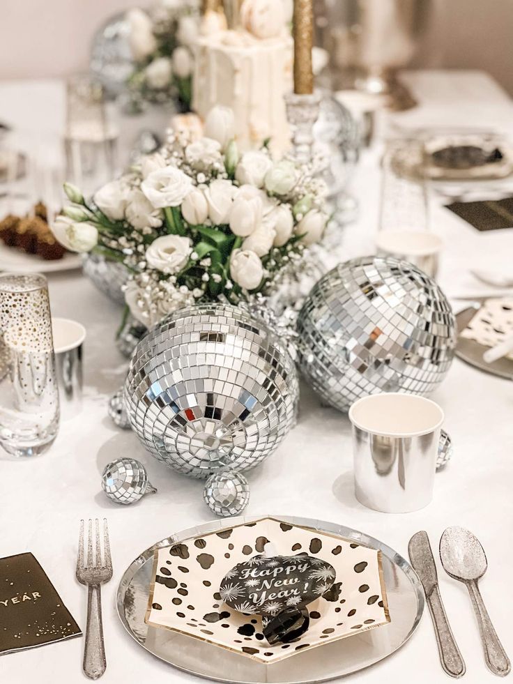 the table is set with silver and white decorations