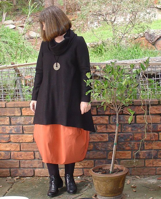 a woman standing next to a small tree