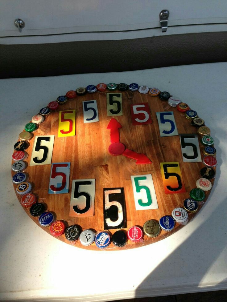 a clock made out of beer caps on the side of a building with numbers painted on it