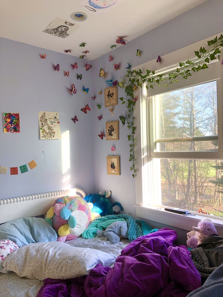 a bedroom with butterflies on the wall and bedding in front of a large window