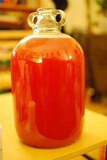 a red glass jar sitting on top of a wooden table