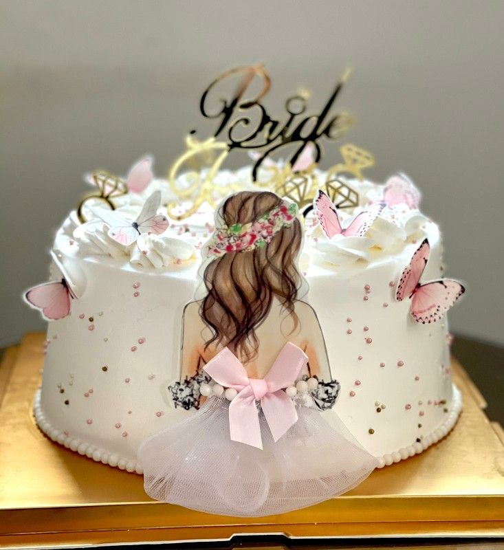 there is a cake that has a girl on it and butterflies around the top of it