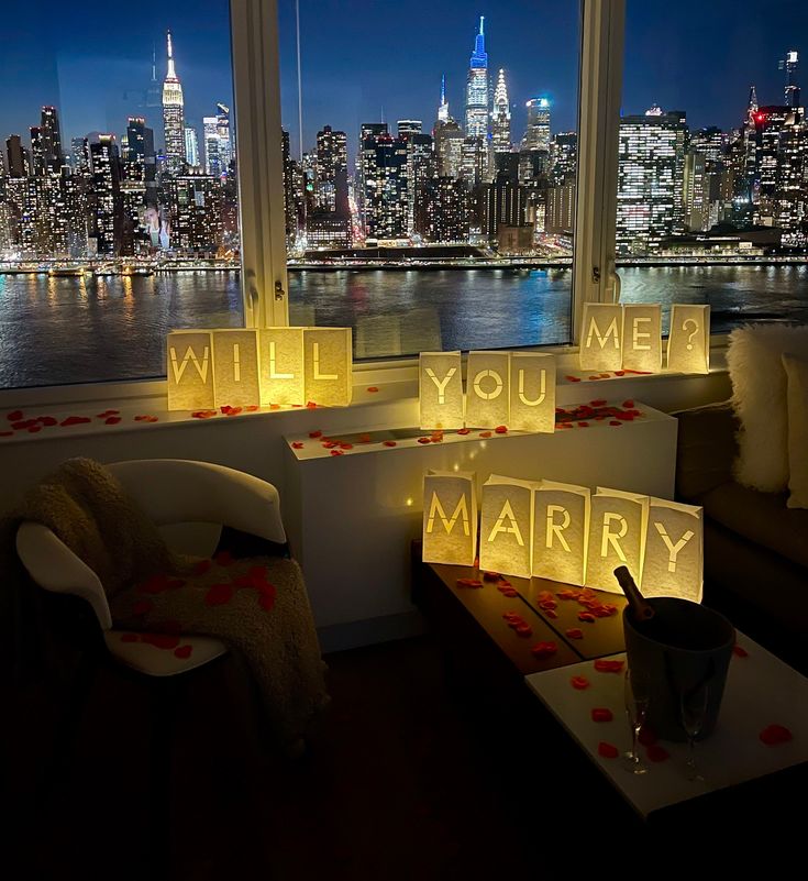 a room with some lights on the windows and a table in front of it that says, will you marry?