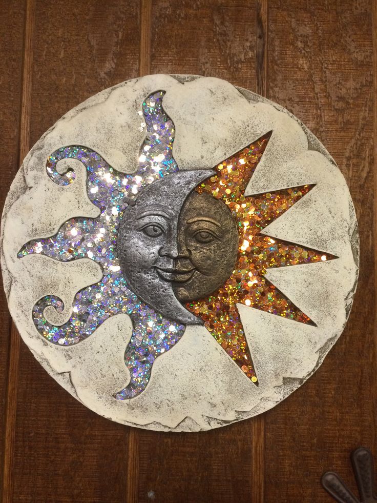 a decorative sun and moon on a wooden surface