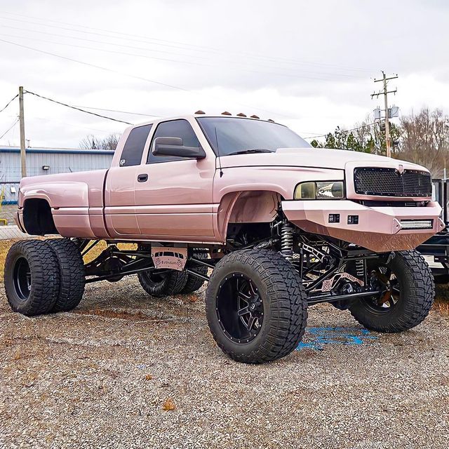 a pink pick up truck parked in a parking lot