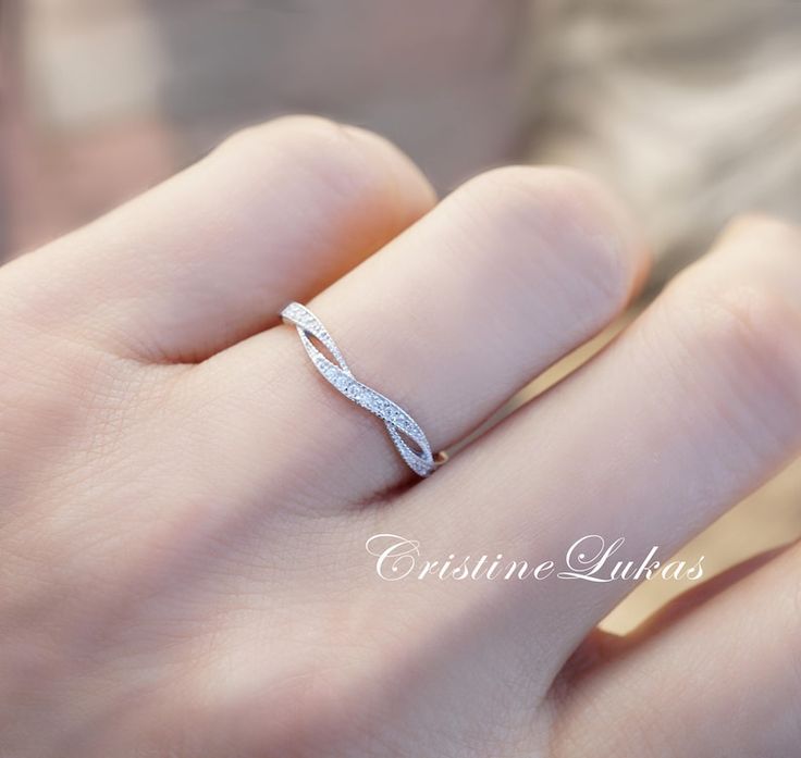 a woman's hand with a diamond ring on her left hand and the word love written in white gold