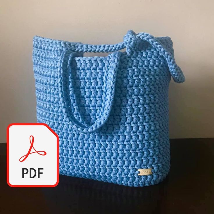 a blue crocheted bag sitting on top of a table