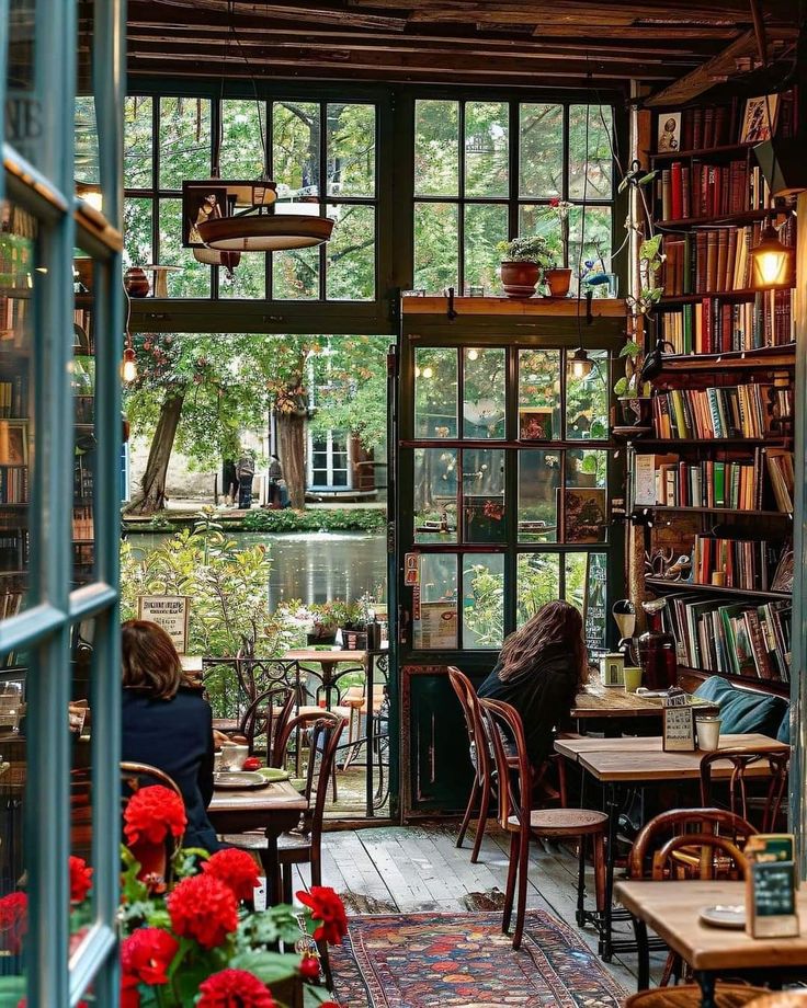 a woman sitting at a table in a room filled with books