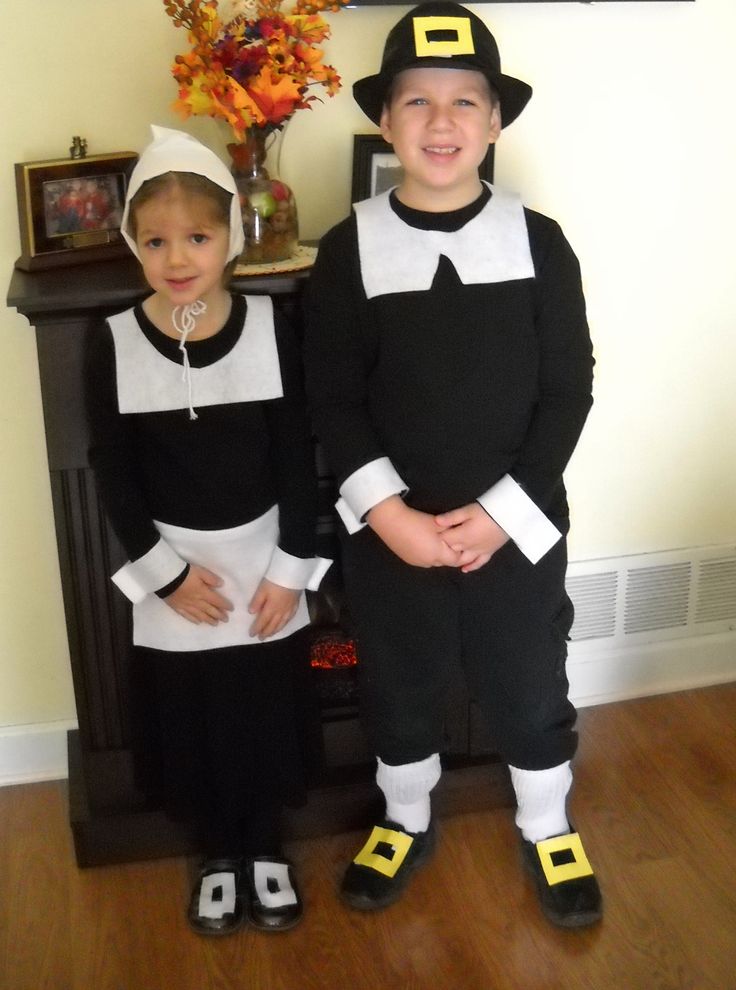 two children dressed up in black and white outfits standing next to each other on a hard wood floor