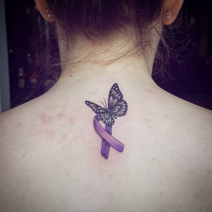 a woman's back neck with a butterfly tattoo on it and a purple ribbon