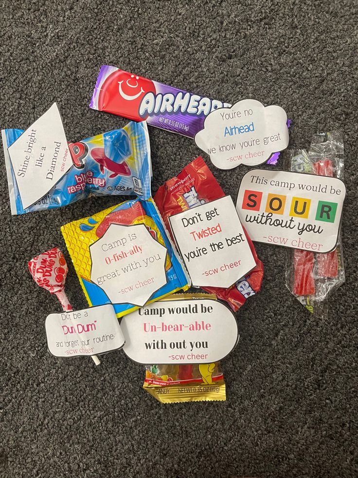 some candy is laying on the floor next to other candies and cards that say, i love you