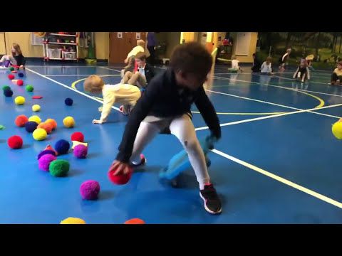 two children playing with balls in an indoor gym