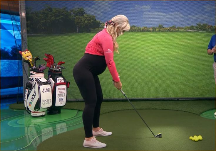 a woman is playing golf on the television set