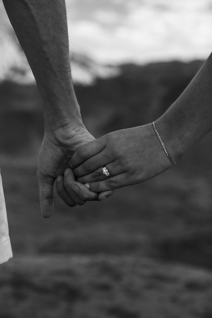 two people holding hands while standing next to each other