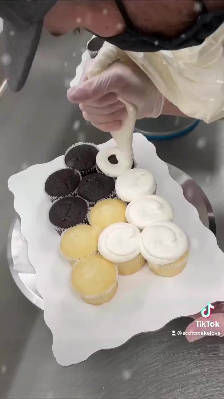 a person is making cupcakes with icing