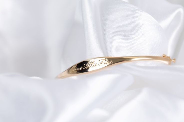 We call her perfect because once we perfected the sample for this bangle, we didn't take her off for 2 years. Fancy, but not too fancy. Just the right shape. Just the right width. The one thing you'll always wear. Solid 14k gold bangle with your name, text or bespoke design Engravable on front and inside Hand engraved to order The Perfect Bangle Sizing Small: 6.3in circumference; 52.10mm x 50.25mm diameter Medium: 6.8in circumference; 56.00mm x 54.00mm diameter Large: 7.2in circumference; 60.00m Elegant Engraved Rose Gold Bracelet, Elegant Cuff Bracelet With Engraving Option For Gift, Elegant Adjustable Cuff Bracelet With Engraving Option, Adjustable Elegant Name Bracelet With Engraving Option, Elegant Adjustable Name Bracelet With Engraving Option, 14k Gold Hallmarked Cuff Bracelet For Anniversary, Engravable Bangle Bracelet For Anniversary, Hallmarked 14k Gold Cuff Bracelet For Anniversary, Anniversary Bangle Bracelet With Engraving Option