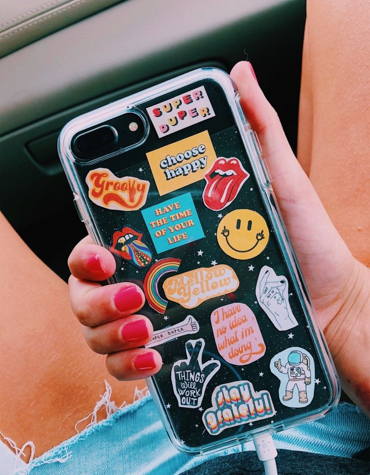 someone is holding their phone with stickers on it