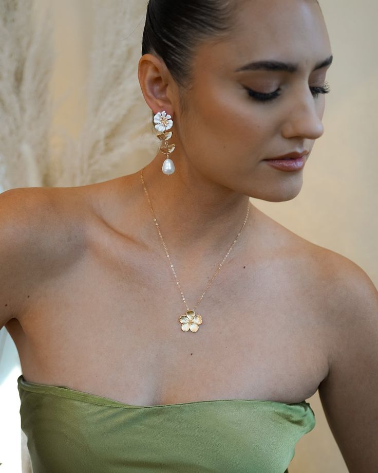 This Bloom Gold Necklace is perfect for letting your beauty blossom! Its golden brilliance sparkles like sunshine, and is sure to turn heads. Add a touch of glamour and make a statement with this gorgeous piece! NECKLACE FEATURES Material: Brass Size: 22.5 x 21.9mm 18K Matte Gold Plated Flower Charm 14K gold filled cable chain & necklace findings Model is wearing 18" length Glamorous Gold Bridal Necklace As Gift, Glamorous Gold Bridal Necklace Gift, Flower Pendant Jewelry With Flower Charm For Party, Gold Plated Flower Shaped Wedding Necklaces, Gold Plated Flower Shaped Necklace For Wedding, Flower Charm Pendant Jewelry For Party, Wedding Gold Plated Flower Shaped Necklace, Gold Flower Pendant Necklace For Party, Delicate Gold Bridal Necklace For Party