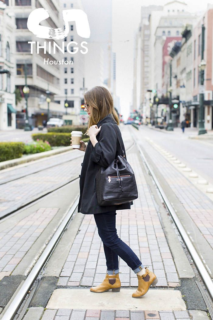 the woman is walking down the street with her coffee