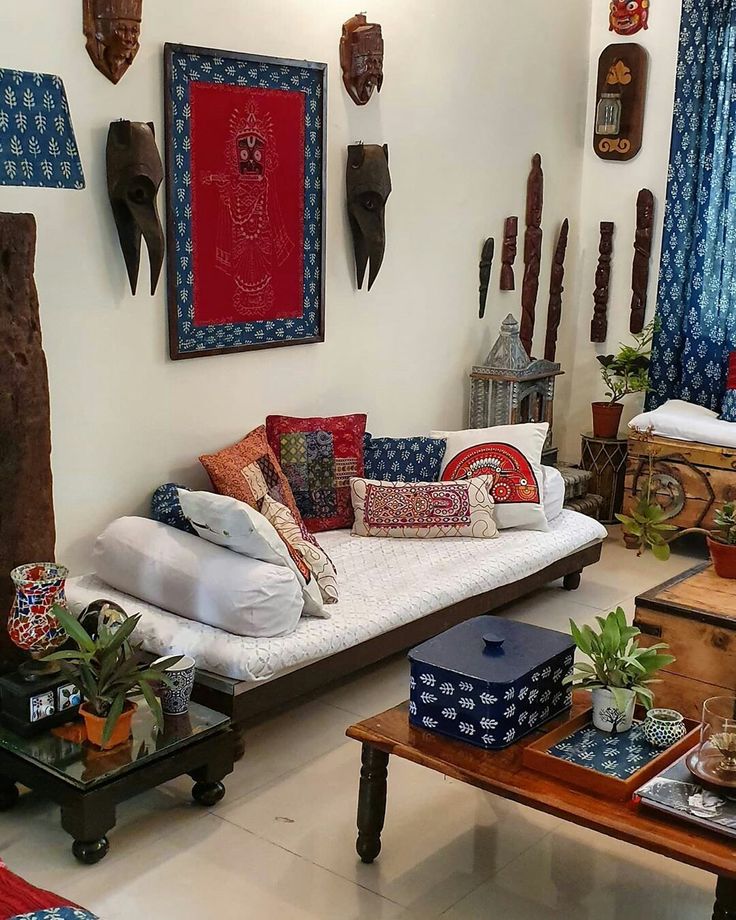 a living room filled with lots of different types of pillows and decor on the walls