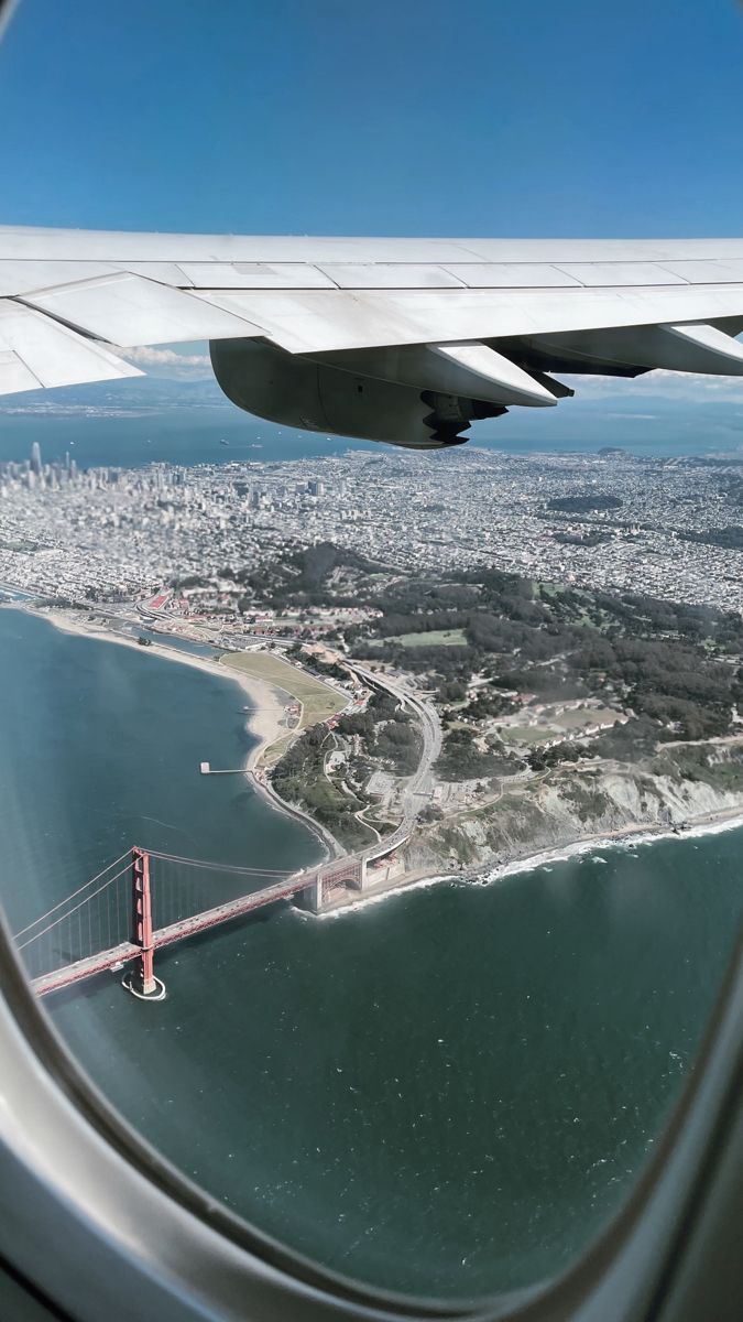 an aerial view of the golden gate bridge and san francisco, california from inside an airplane